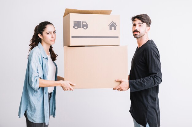 Concept de déménagement avec couple transportant deux boîtes