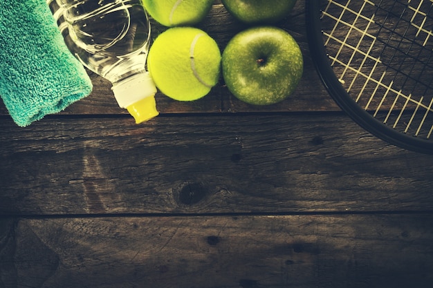 Concept du sport vie saine. Sneakers avec des pommes, des serviettes et une bouteille d&#39;eau sur fond en bois. Espace de copie.