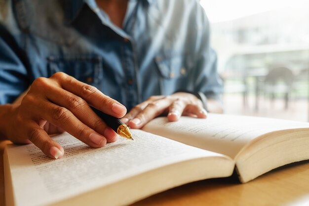 Concept d&#39;éducation. Étudiant étudiant et faisant un remue-méninges sur le concept du campus. Gros plan des étudiants qui discutent de leur sujet sur des livres ou des manuels scolaires. Mise au point sélective.