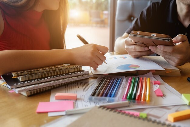 Concept d&#39;éducation. Étudiant étudiant et faisant un remue-méninges sur le concept du campus. Gros plan des étudiants qui discutent de leur sujet sur des livres ou des manuels scolaires. Mise au point sélective.