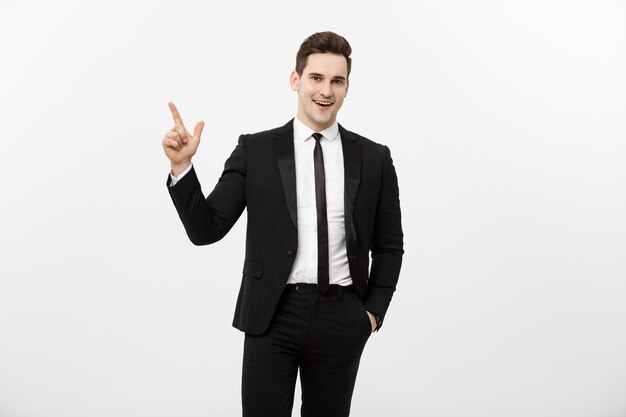Concept d'entreprise : bel homme d'affaires avec un doigt pointé vers le haut isolé sur fond blanc