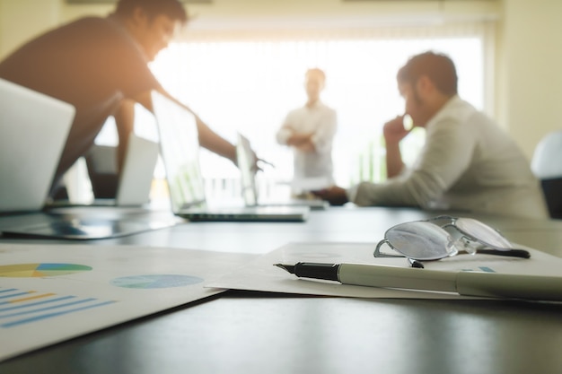 Concept d&#39;entreprise avec espace de copie. Table de bureau avec stylo et tableau d&#39;analyse, ordinateur, ordinateur portable, tasse de café sur le bureau. Tonalité de rétro Filtre rétro, mise au point sélective.