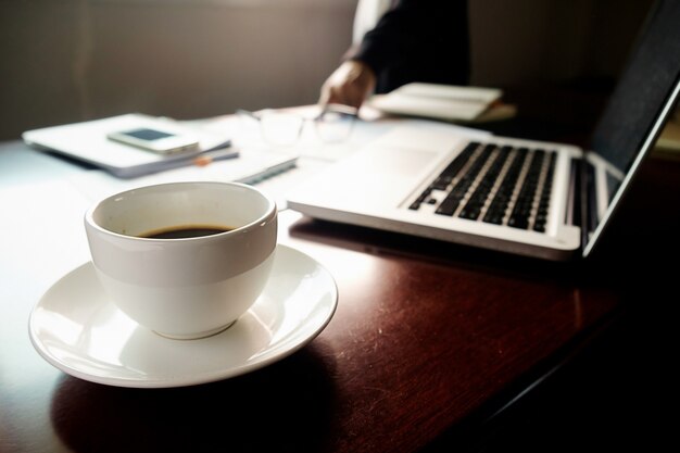 Concept d&#39;entreprise avec espace de copie. Table de bureau avec stylo et tableau d&#39;analyse, ordinateur, ordinateur portable, tasse de café sur le bureau. Tonalité de rétro Filtre rétro, mise au point sélective.