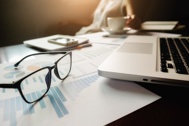 Concept d&#39;entreprise avec espace de copie. Table de bureau avec stylo et tableau d&#39;analyse, ordinateur, ordinateur portable, tasse de café sur le bureau. Tonalité de rétro Filtre rétro, mise au point sélective.