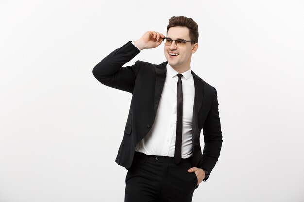 Concept d'entreprise : jeune bel homme d'affaires portant des lunettes tenant la main dans la poche isolé sur fond blanc.