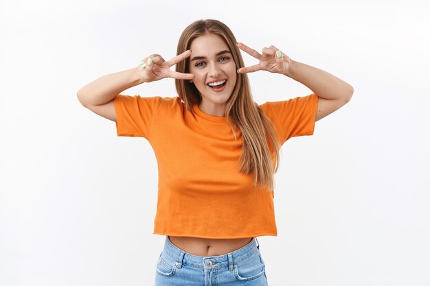 Concept d'été, d'étudiants et de jeunes. Portrait de joyeuse fille blonde envoyant des ondes positives