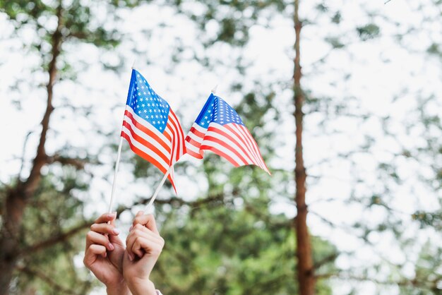 Concept de la fête de l&#39;indépendance avec une femme tenant deux drapeau américain
