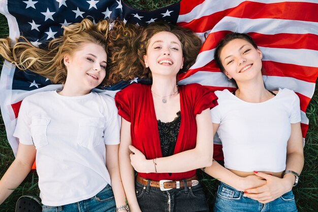 Concept de la fête de l&#39;indépendance avec des filles allongées sur le drapeau américain