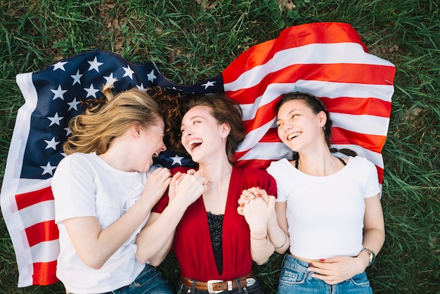 Photo gratuite concept de la fête de l'indépendance avec des filles allongées sur le drapeau américain
