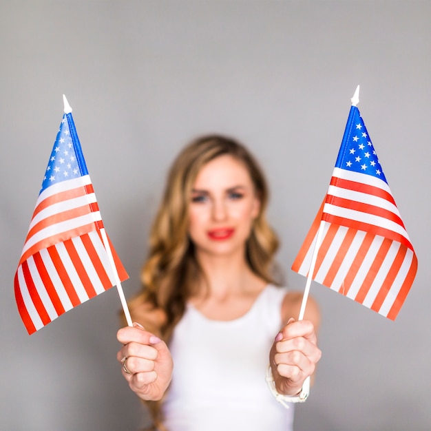 Concept de fête de l&#39;indépendance des États-Unis avec femme tenant deux drapeaux