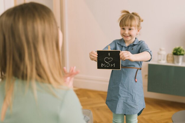 Concept de fête des mères avec enfant montrant ardoise