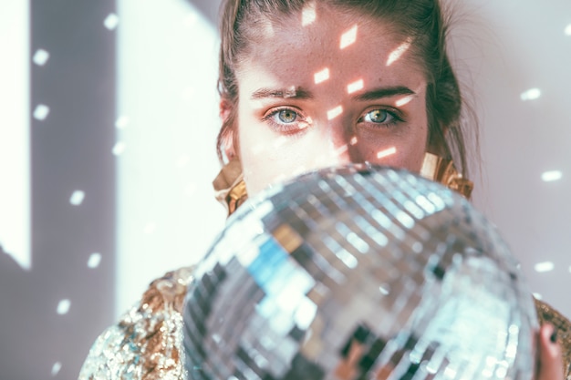 Photo gratuite concept de fête de nouvel an avec une fille derrière une boule disco