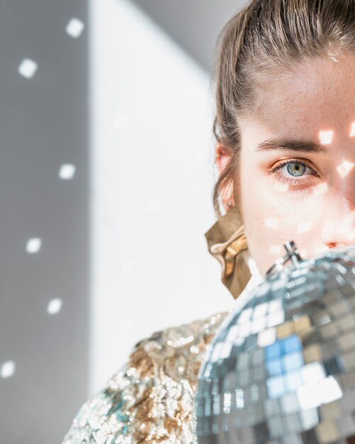 Concept de fête de nouvel an avec une fille derrière une boule disco