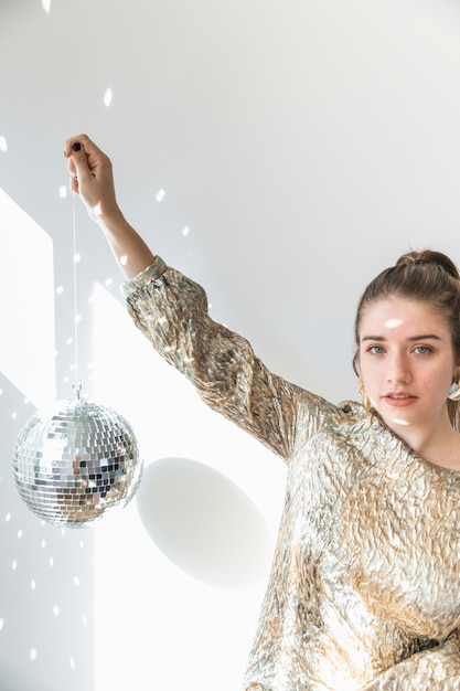 Concept de fête de nouvel an avec fille tenant une boule disco