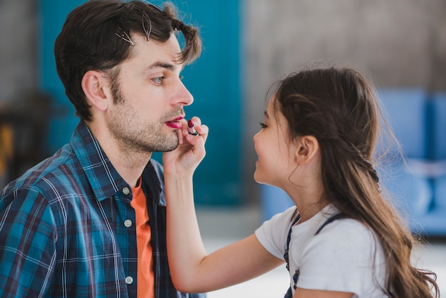 Photo gratuite concept de fête des pères avec la fille peinture lèvres des pères