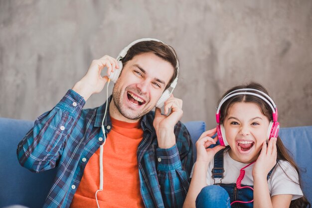 Concept de fête des pères avec père et fille écoutant de la musique