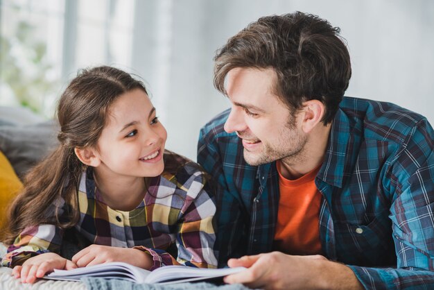 Le concept de la fête des pères avec le père et la fille lisant
