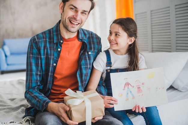 Concept de fête des pères avec père et fille tenant des cadeaux