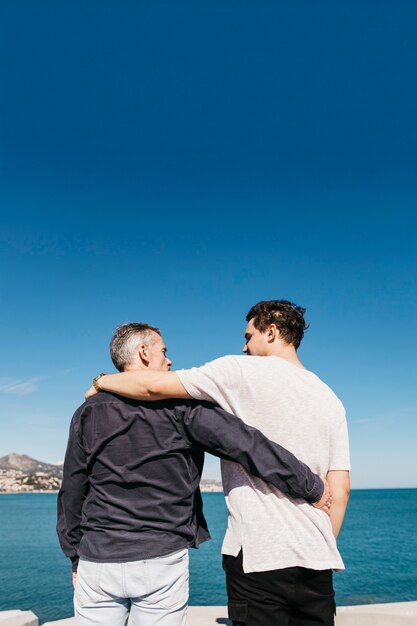 Concept de fête des pères avec père et fils en face de la mer