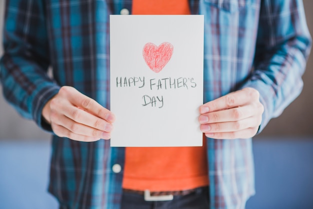 Concept de fête des pères avec père tenant la carte dessinée avec coeur à la main