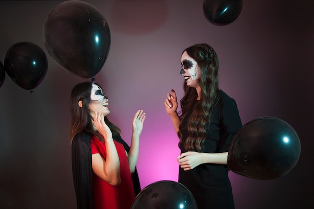 Photo gratuite concept d'halloween avec des femmes qui rient et des ballons