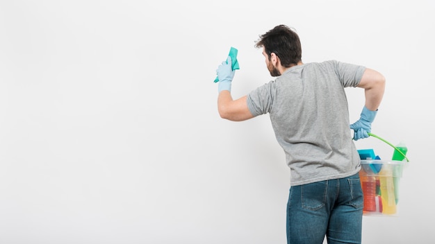 Concept d&#39;homme nettoyant sa maison avec la surface sur le mur