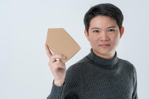 Concept d'idées d'affaires d'actif de prêt à domicile homme asiatique main tenir maison papier modèle fond blanc