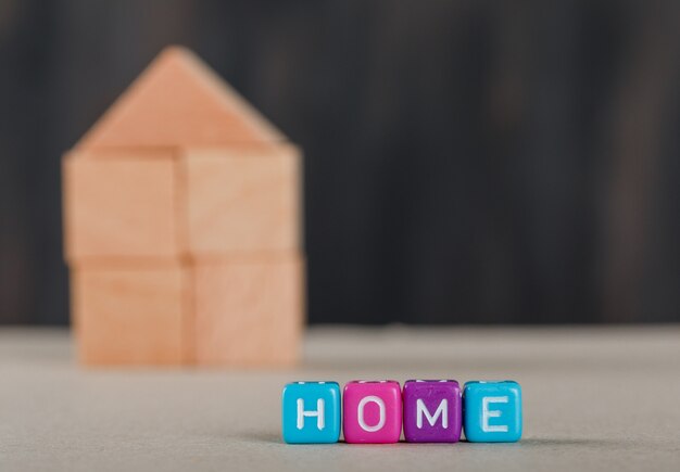 Concept immobilier avec des cubes colorés, maison en bois et blanc.