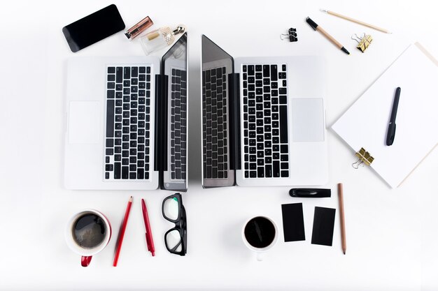 Concept de lieux de travail masculins et féminins confortables. Gadgets élégants sur le bureau blanc.