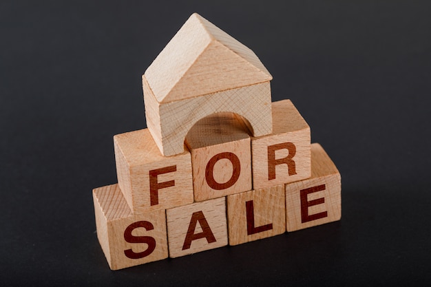 Photo gratuite concept de logement à vendre avec des cubes en bois, maison de jouet en bois sur une hauteur sombre.