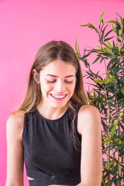 Photo gratuite concept de mode de l'été avec la jeune femme en face des plantes