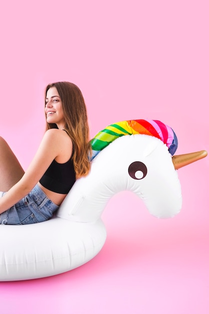 Concept de mode de l&#39;été avec une jeune femme sur licorne gonflable