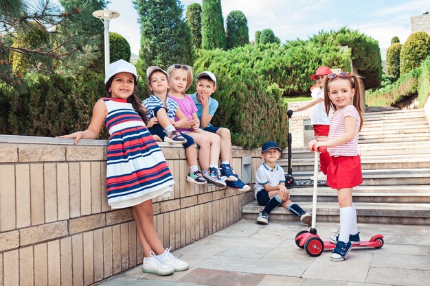 Concept de mode pour enfants. groupe d'adolescents garçons et filles posant au parc. Vêtements colorés pour enfants, style de vie, concepts de couleurs à la mode.