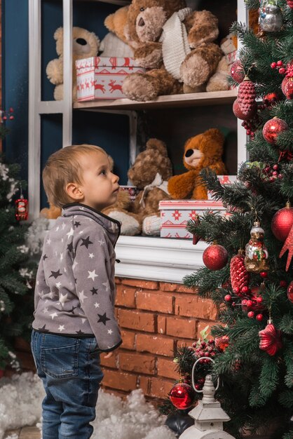Concept de Noël avec enfant regardant l&#39;arbre de Noël