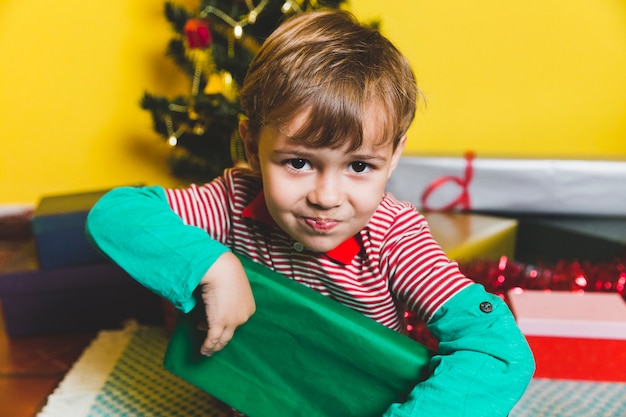 Photo gratuite concept de noël avec enfant tenant une boîte-cadeau verte