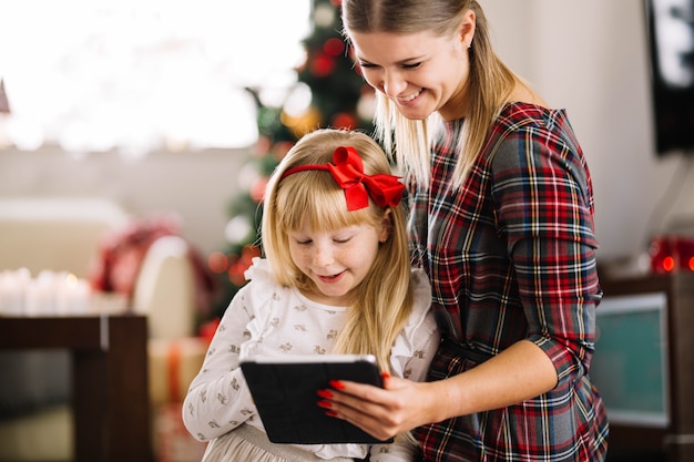 Concept de Noël avec la famille en regardant la tablette