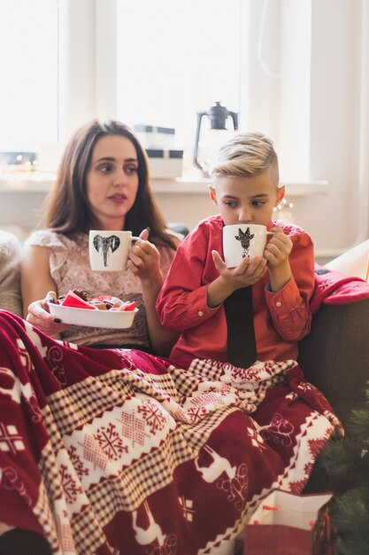 Concept de Noël avec femme et garçon, boire du thé