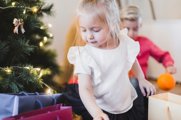 Concept de Noël avec une fille en regardant les cadeaux