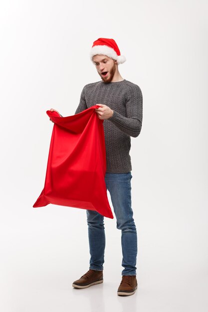 Concept de Noël jeune barbe bel homme passionnant ouvert santa grand sac pour le présent