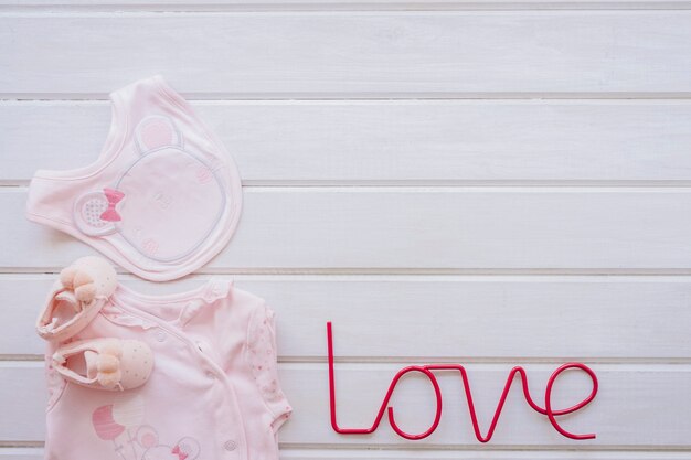 Concept nouveau-né avec des vêtements pour bébés et des lettres d&#39;amour