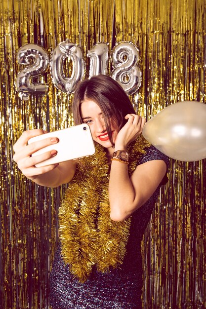 Concept de nouvel an avec une fille souriante prenant selfie