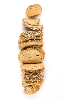 Concept de pain de nombreuses tranches de pain de blé entier avec des graines disposées en ligne au milieu sur fond blanc.