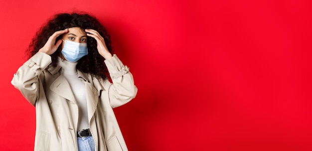 Photo gratuite concept de pandémie et de quarantaine covid élégante jeune femme aux cheveux bouclés sortant en médecine m