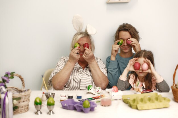 Concept de Pâques. Petite fille avec frère et grand-mère à colorier des oeufs pour Pâques.