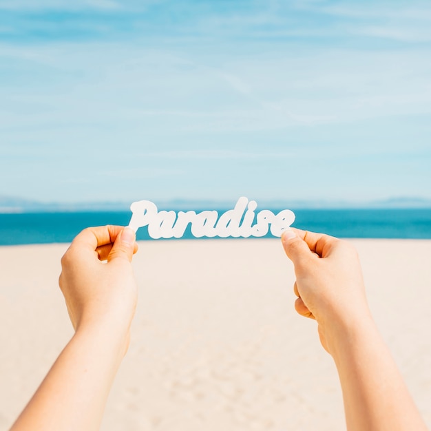 Photo gratuite concept de plage avec des mains tenant des lettres de paradis