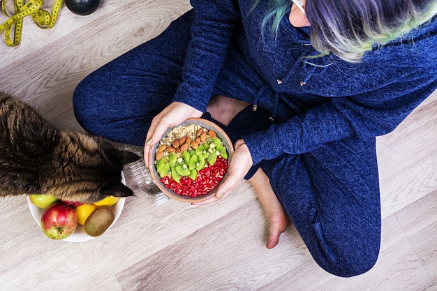 Concept de remise en forme et de mode de vie sain. La femelle se repose et mange une farine d'avoine saine après une séance d'entraînement. Vue de dessus.