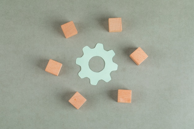 Concept de réparation avec des cubes en bois, symbole de paramètres sur table grise à plat.