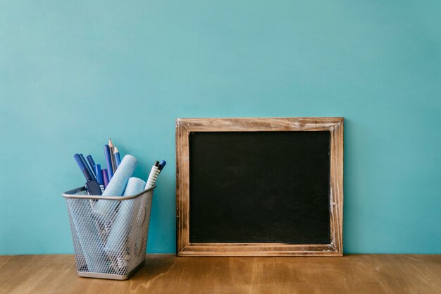 Concept de retour à l'école avec ardoise appuyée contre le mur