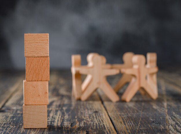 Concept de réussite commerciale et de travail d'équipe avec des figures en bois de personnes, vue de côté de cubes.