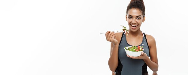 Concept de santé et de remise en forme belle dame africaine américaine en vêtements de fitness sur le régime alimentaire manger frais